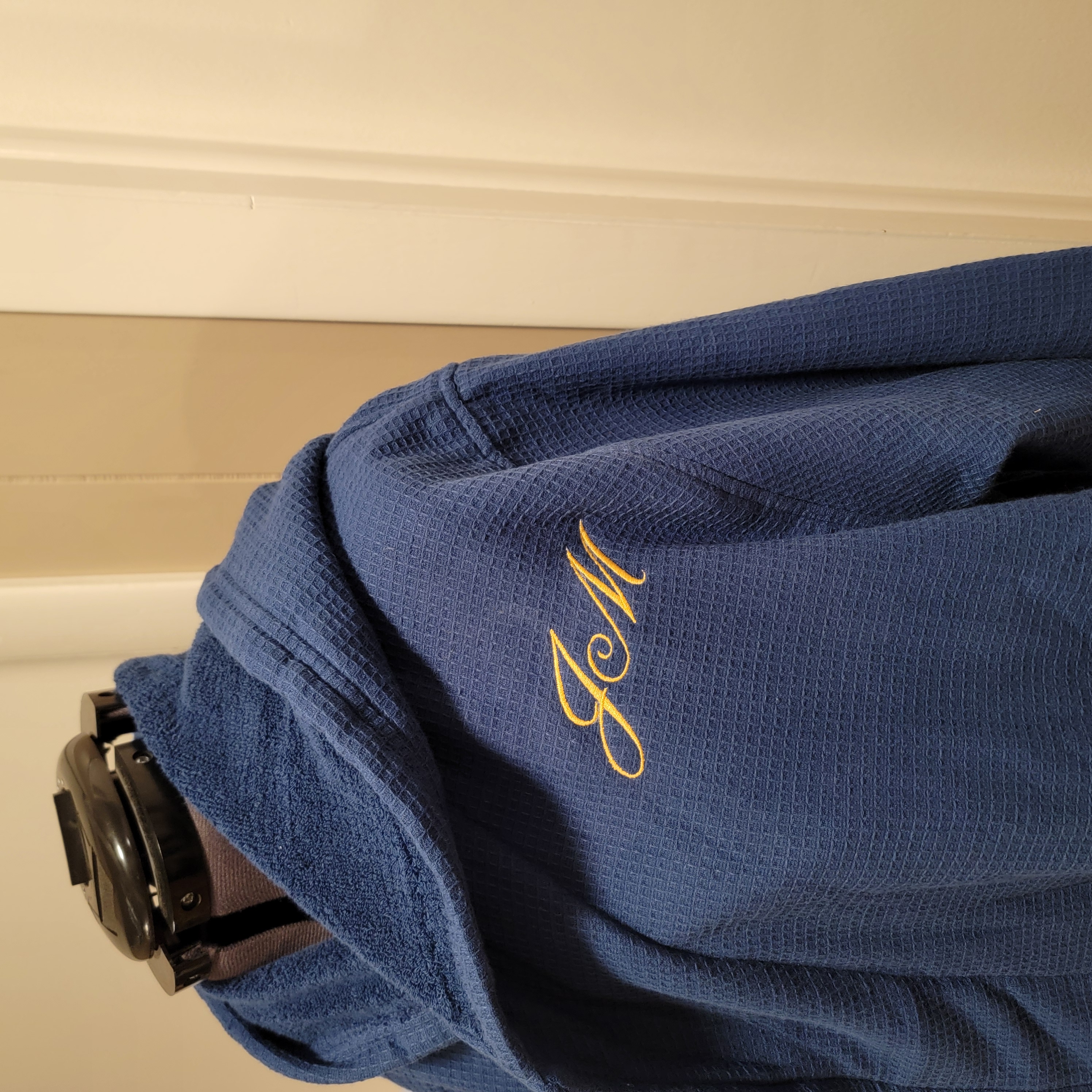 Clean gold monogram embroidery on professional blue apparel